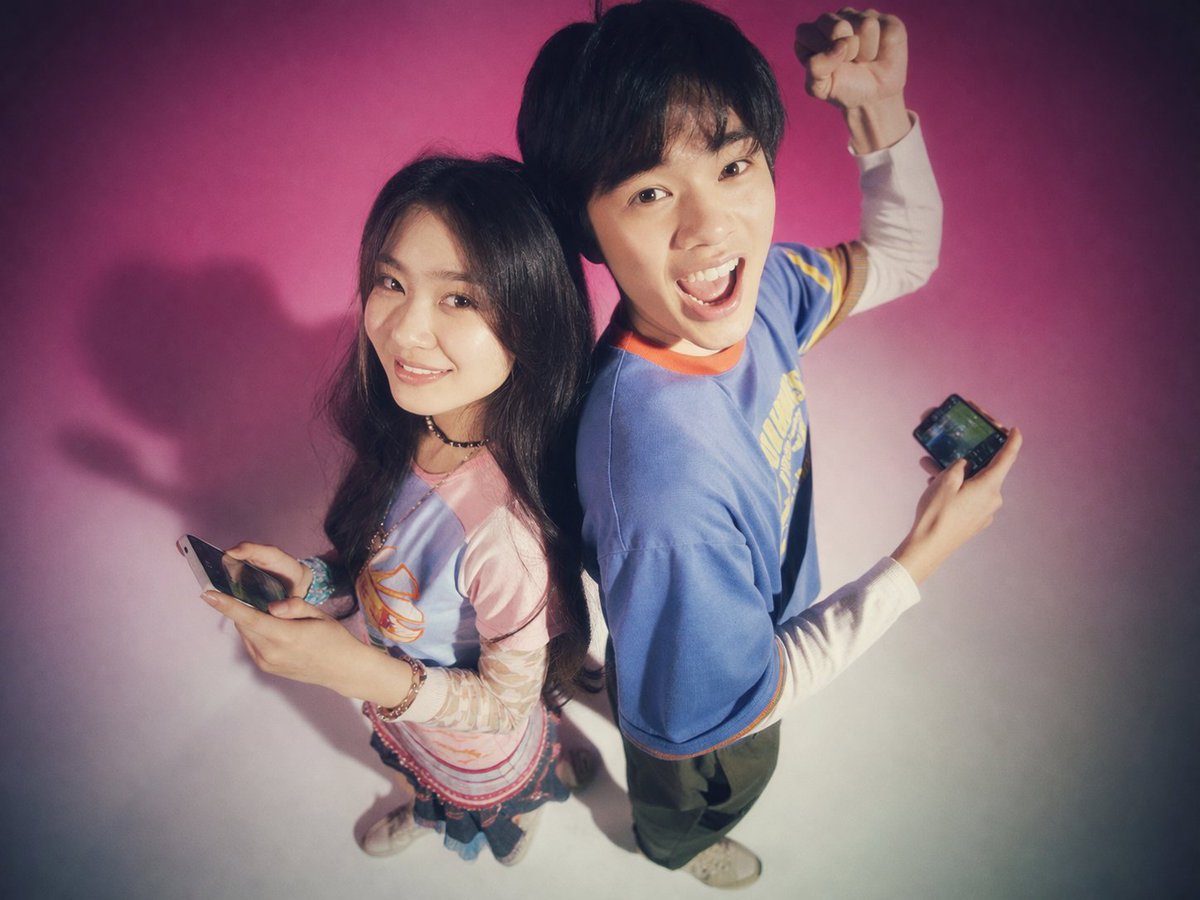 Y2K Teen Magazine Studio Portrait 的 Qwen Image 提示词示例图 变化图 2：Generates a nostalgic, soft-focus studio portrait of two young adults posing back-to-back with smartphones, perfect...