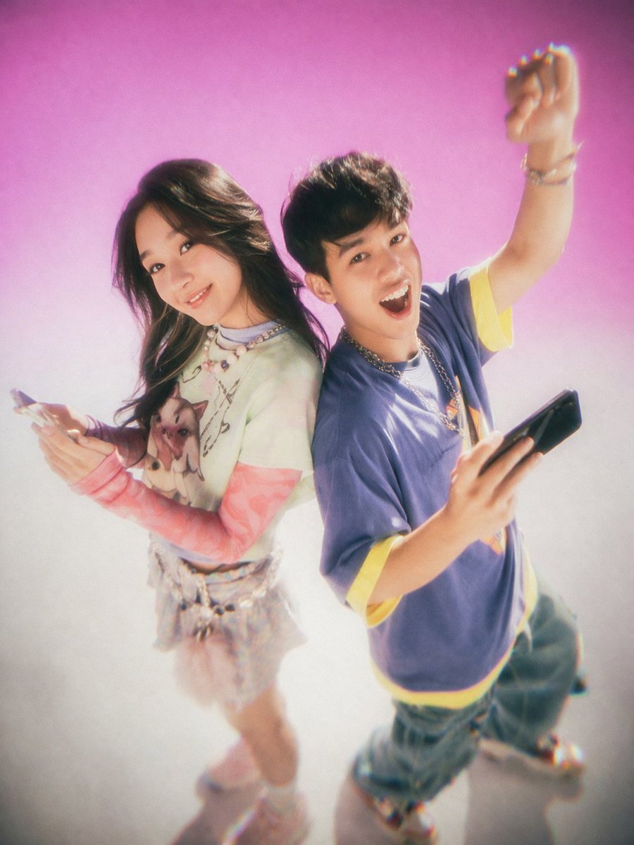 Y2K Teen Magazine Studio Portrait 的 Qwen Image 提示词示例图：Generates a nostalgic, soft-focus studio portrait of two young adults posing back-to-back with smartphones, perfect for...