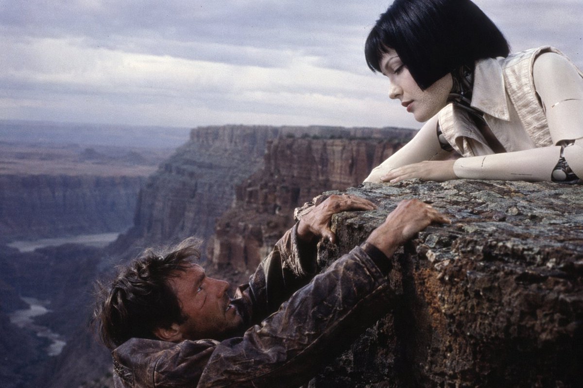 90s Sci-Fi Cliffhanger Movie Still Qwen Image prompt example: Generates a cinematic movie still featuring a character hanging from a cliff while an android looks on, perfect for...