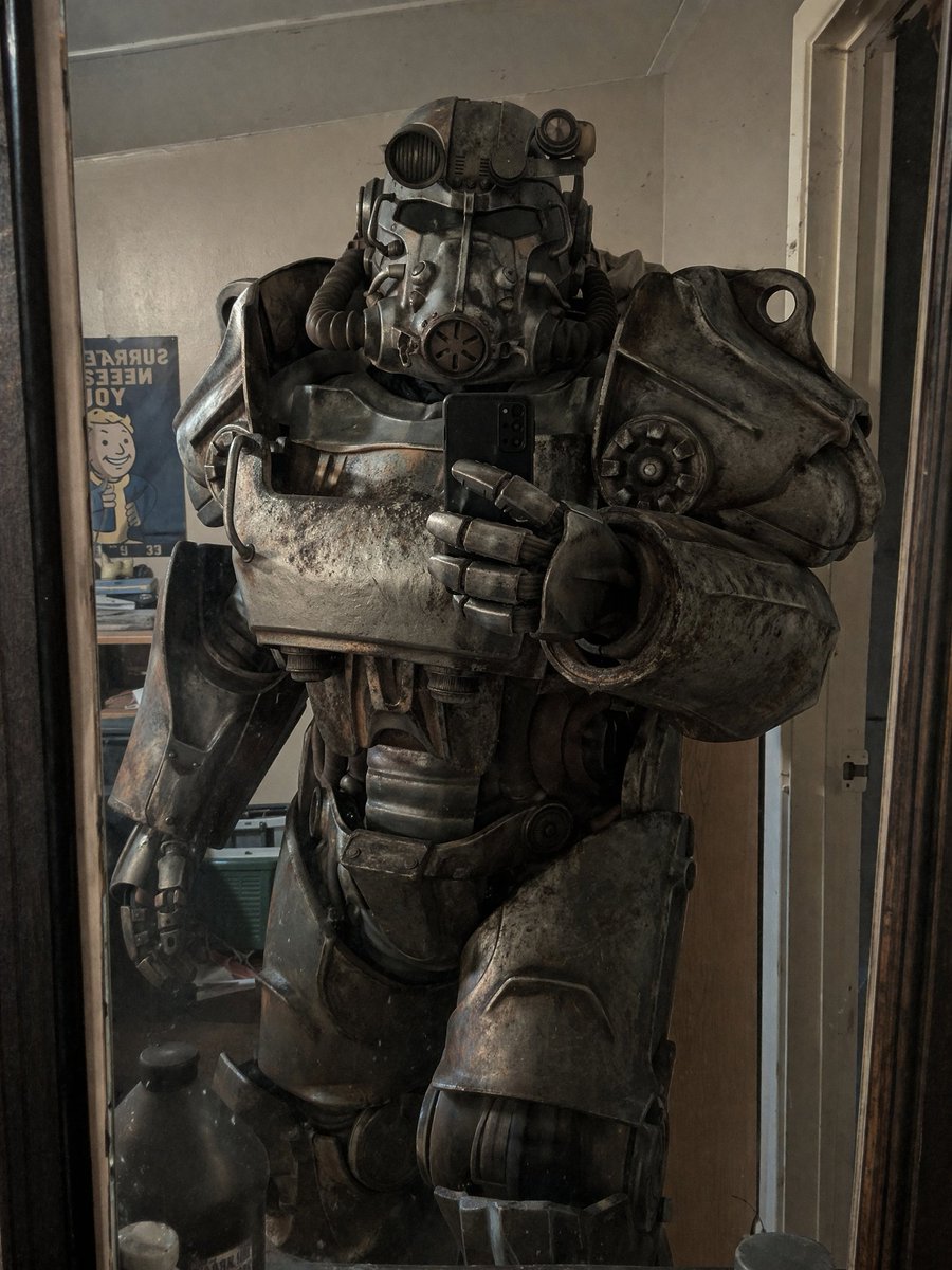Power Armor Mirror Selfie のQwen Imageプロンプト例: Generates a realistic image of someone in weathered power armor taking a mirror selfie in a messy room.