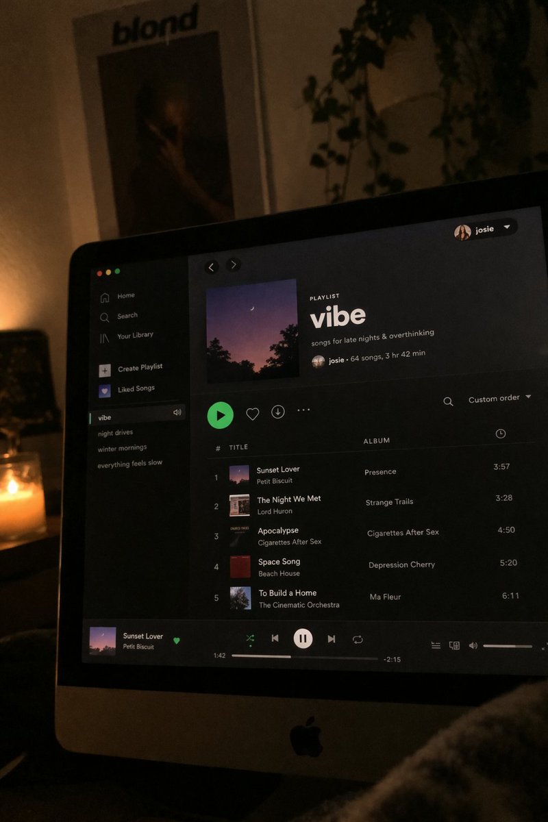 Spotify Playlist Screen at Night のQwen Imageプロンプト例: A photorealistic prompt depicting a computer screen displaying a music playlist at night, demonstrating high-quality text and...