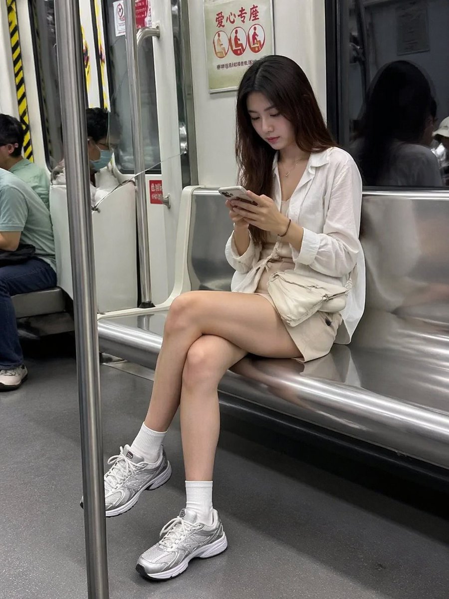 Candid Subway Photography Style GPT Image 2 prompt example: A realistic prompt for generating a candid-style photo of a woman on a subway looking at her phone.