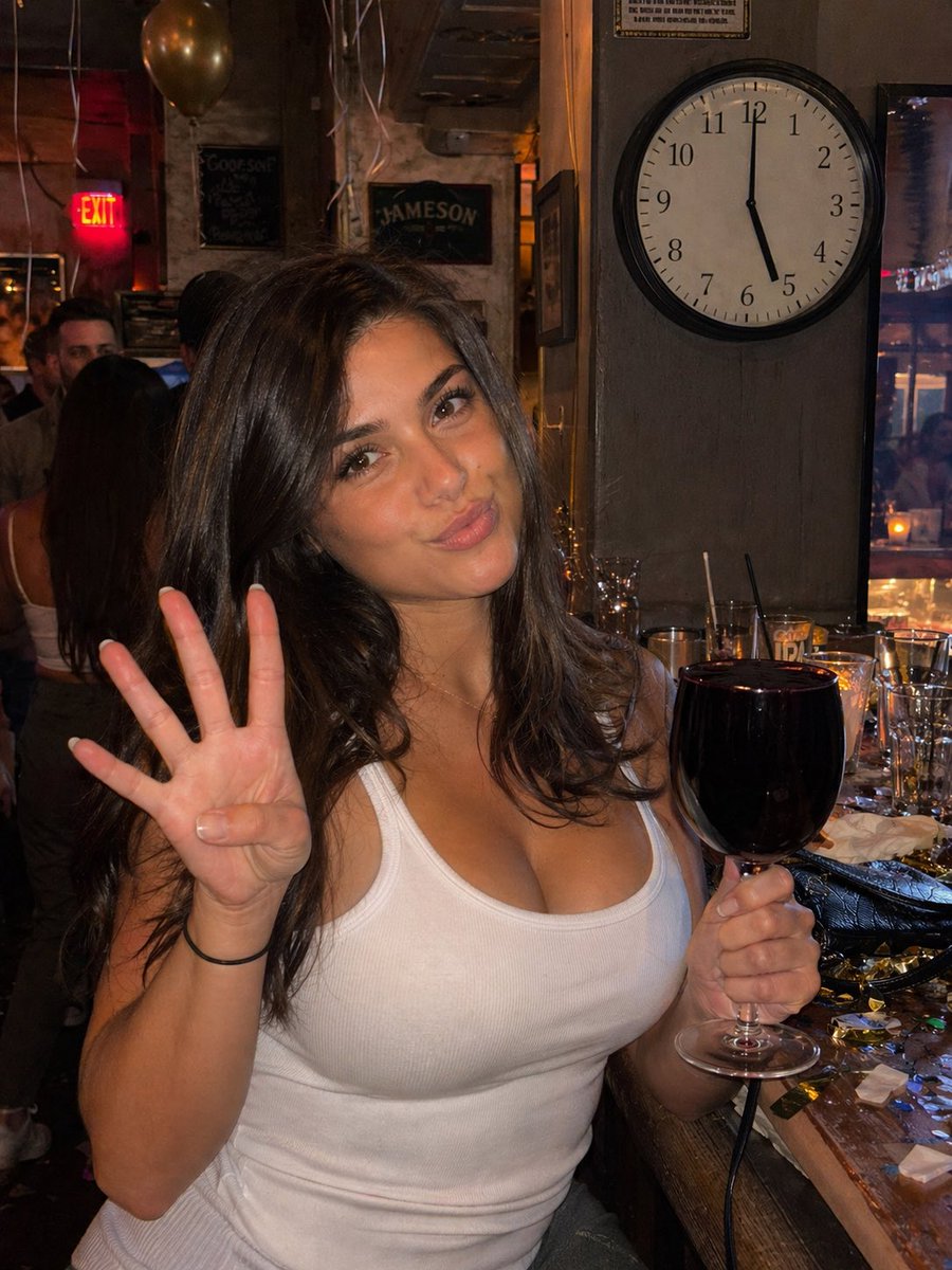 Candid Bar Photo with Four Fingers GPT Image 2 prompt example: A photorealistic smartphone-style bar snapshot of a woman holding a nearly full red wine glass and showing four...