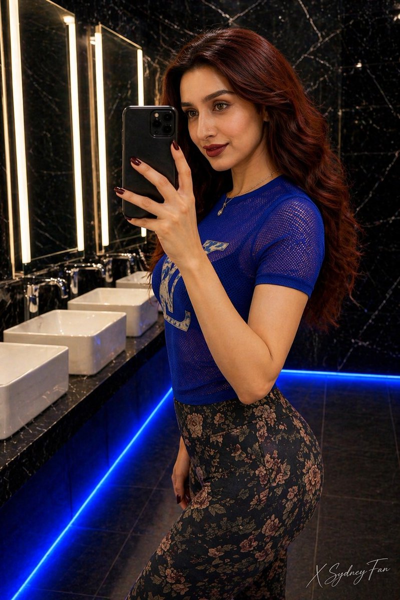 Luxury Restroom Mirror Selfie のQwen Imageプロンプト例 バリエーション 2: A prompt for a high-quality mirror selfie featuring a woman in a designer t-shirt inside a modern, upscale restroom...