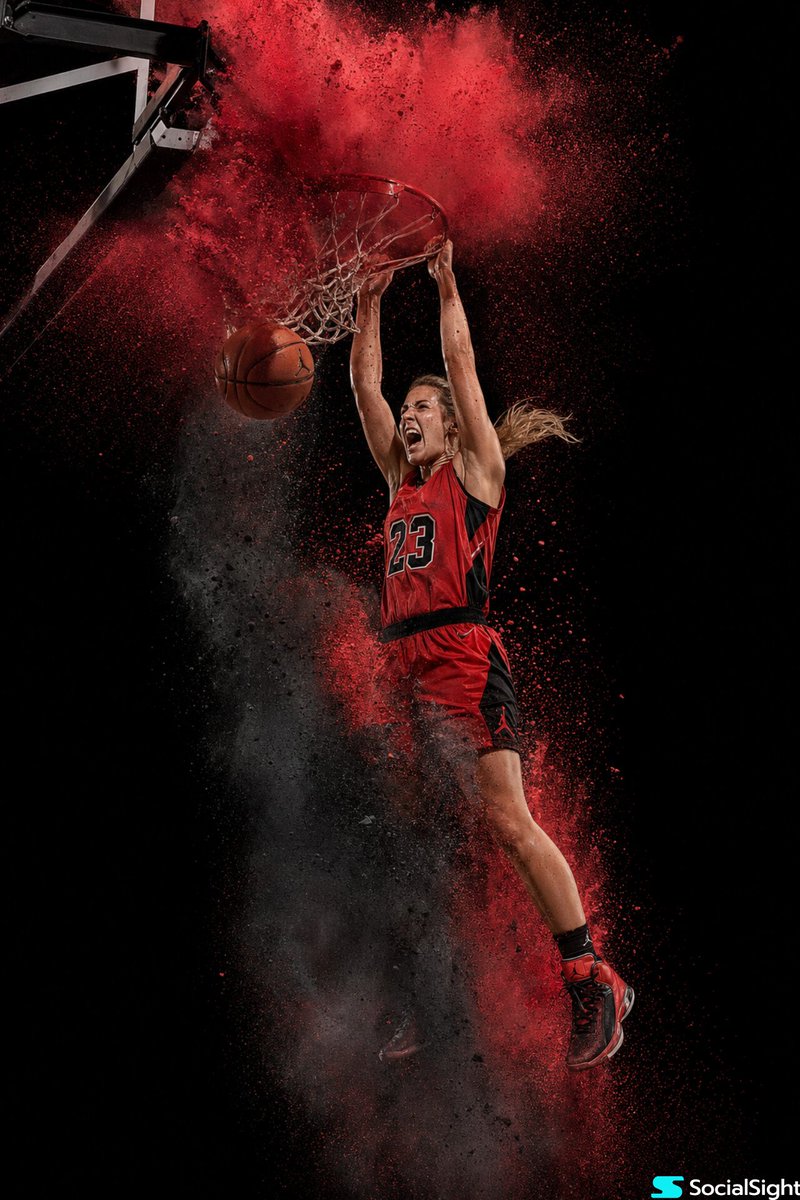 Action Basketball Dunk with Powder Explosion のQwen Imageプロンプト例: A high-speed photography style shot of a basketball player mid-dunk with a dramatic red and charcoal powder...