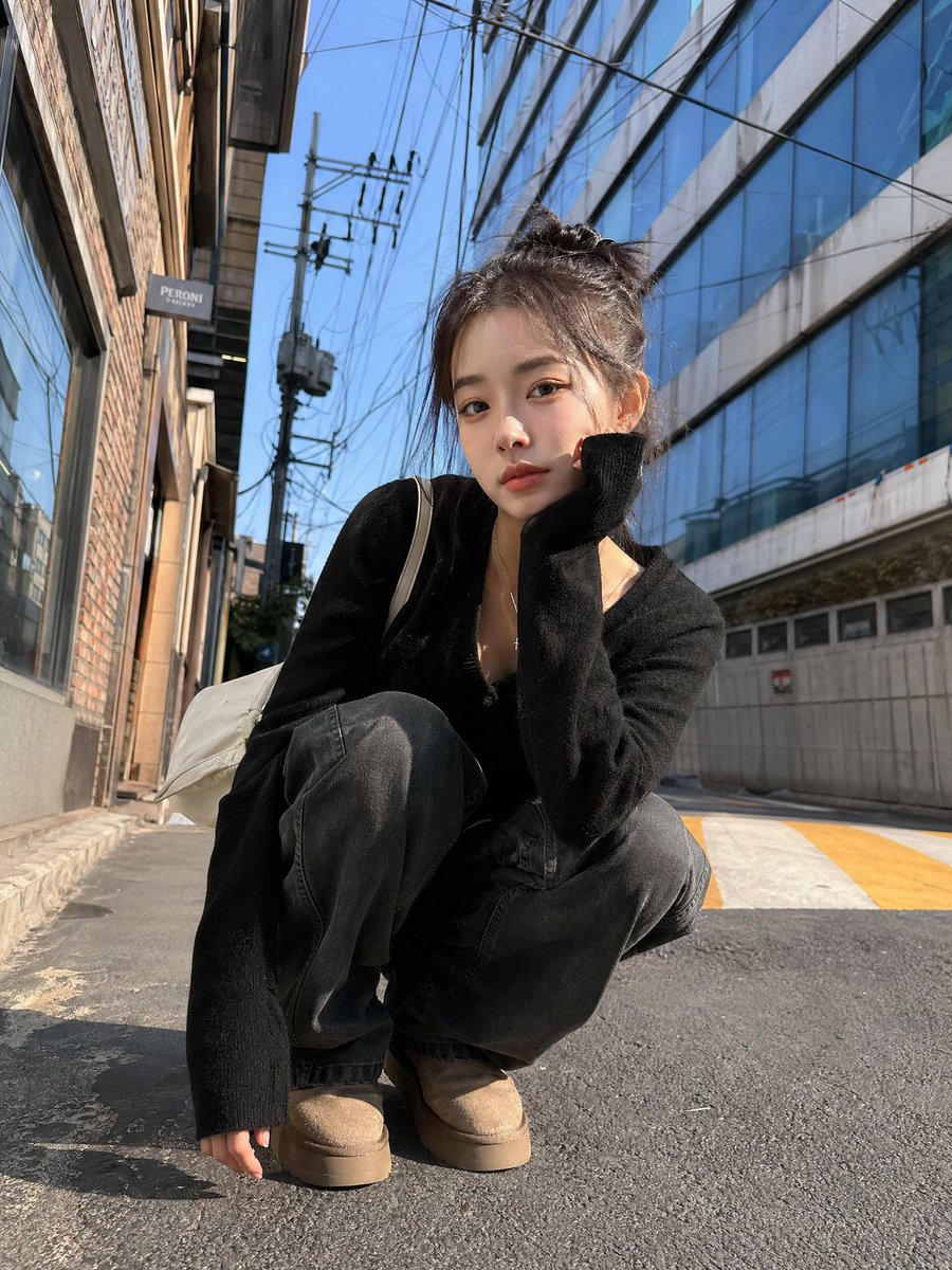 Korean Girl Street Photography 的 Qwen Image 提示词示例图 变化图 3：A dynamic street photography prompt featuring a young woman in a trendy urban setting with a strong low-angle perspective.