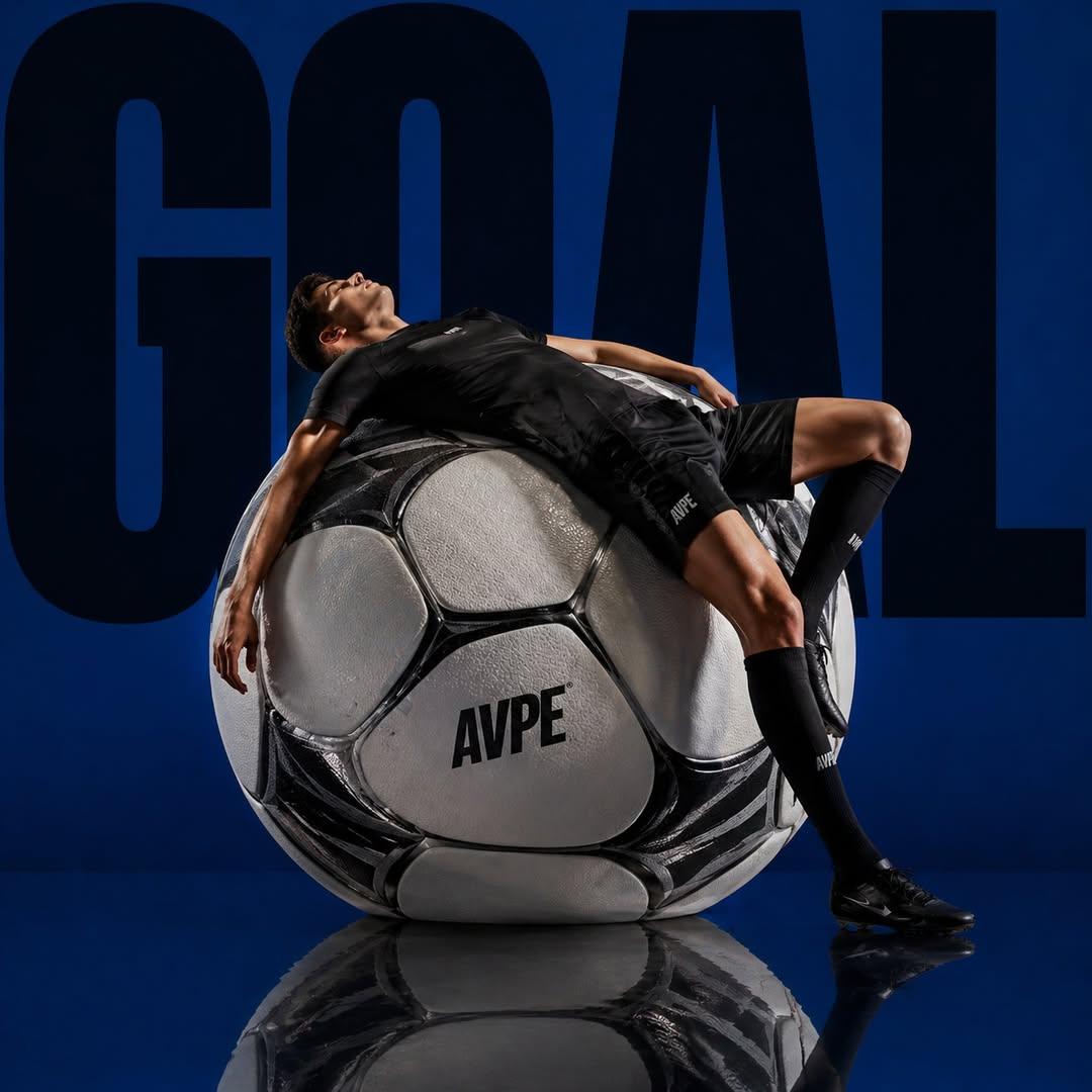 Professional Sports Campaign Portrait 的 GPT Image 2 提示词示例图：A high-contrast luxury sports commercial shot featuring a footballer reclining on an oversized ball with bold...