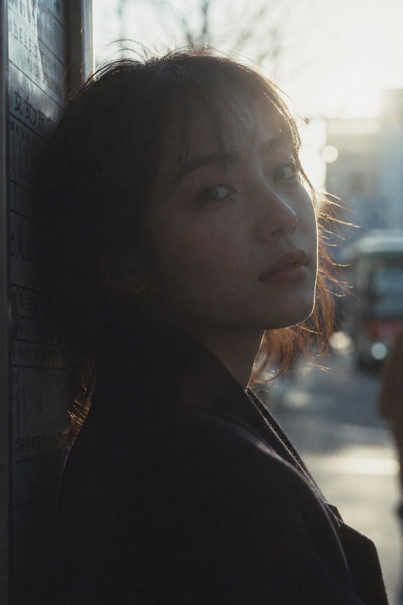 Cinematic Urban Silhouette Portrait GPT Image 2 prompt example: A stylized urban portrait prompt using Japanese film aesthetics to create a backlit silhouette of a person at a...