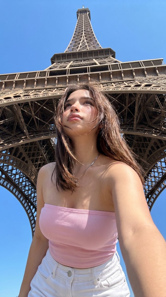 Paris Eiffel Tower Vacation Selfie GPT Image 2 prompt example: A photorealistic low-angle travel selfie prompt for generating a believable summer tourist photo beneath the Eiffel...