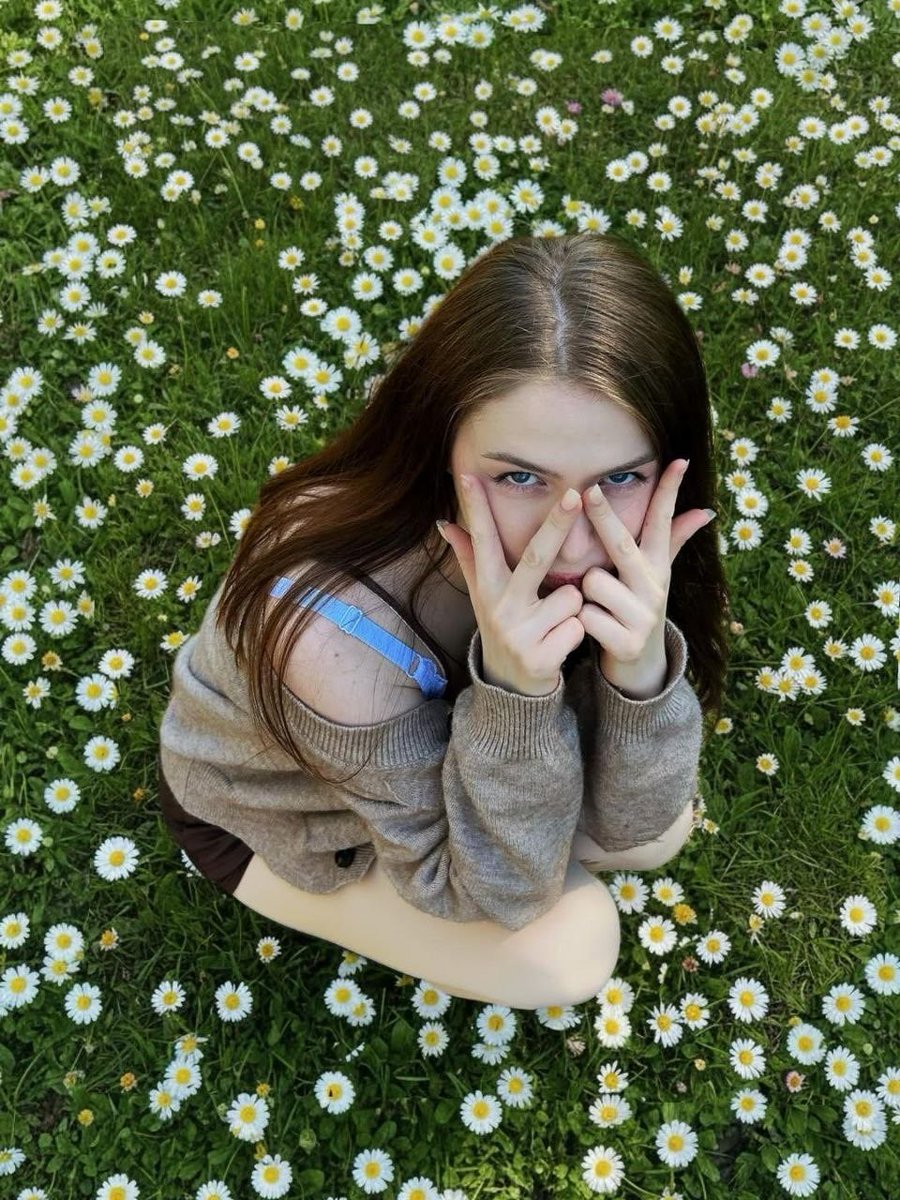 Girl in Daisy Meadow Portrait Qwen Image prompt example variation 2: A soft, whimsically-styled portrait prompt of a woman sitting in a field of daisies with natural daylight.